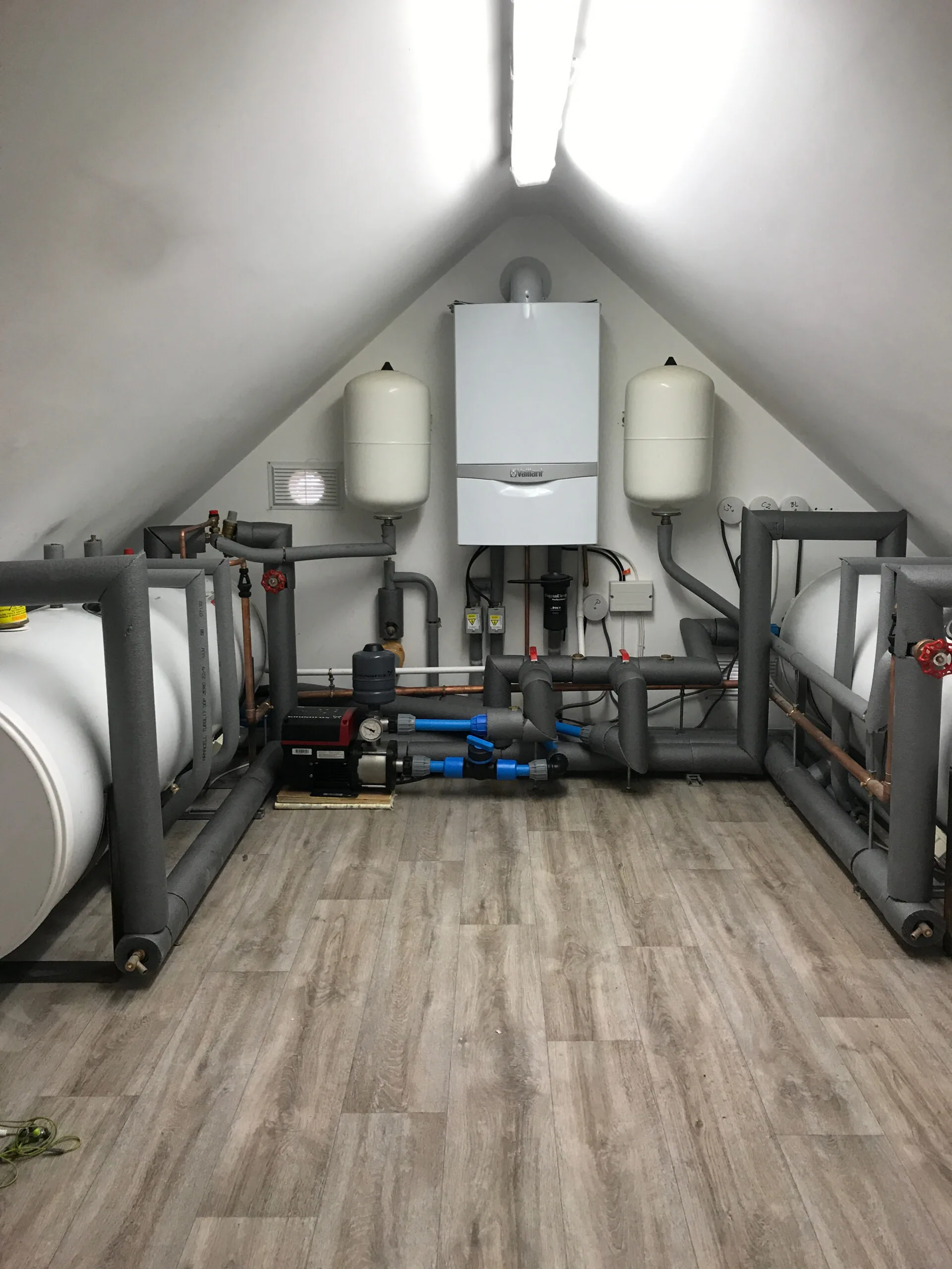 Boiler, insulated pipework and heating equipment in a loft installation