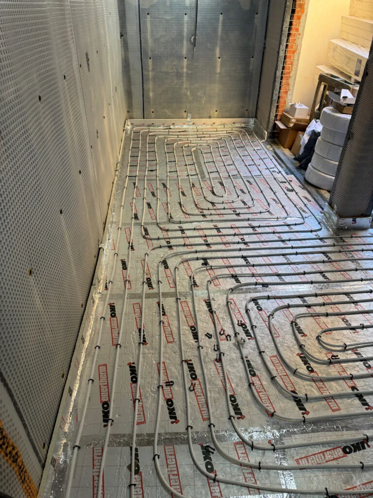 Underfloor heating pipes through an unfinished room