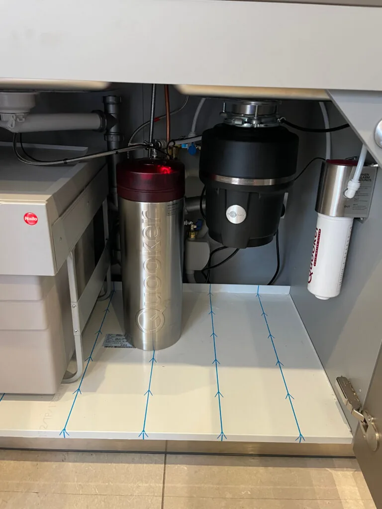 Pipework and equipment below a kitchen sink