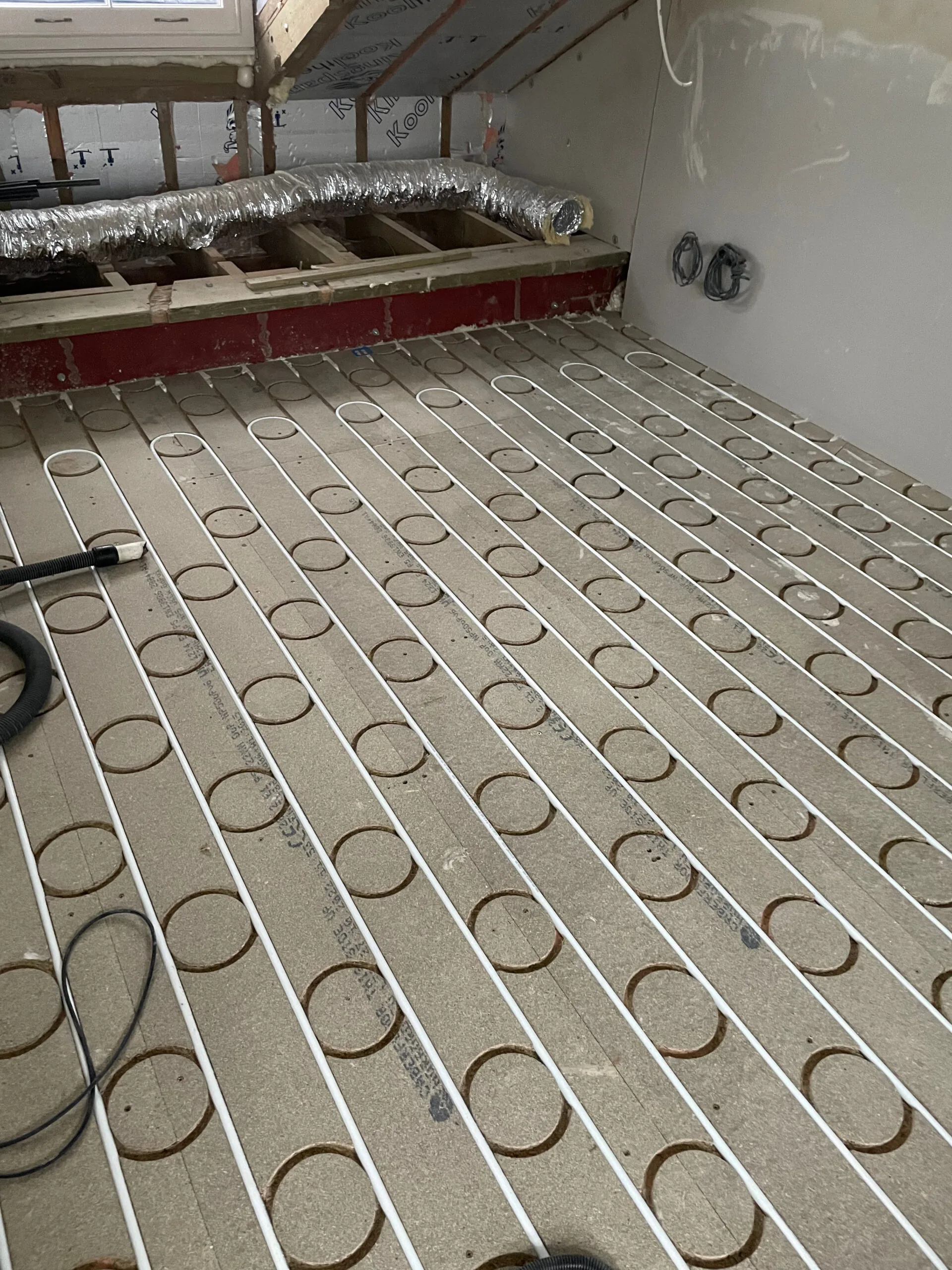 Underfloor heating pipe loops fitted into floor panels