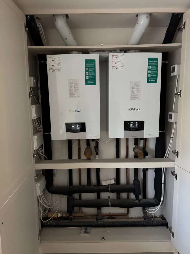 Two wall-mounted boilers with connected pipework